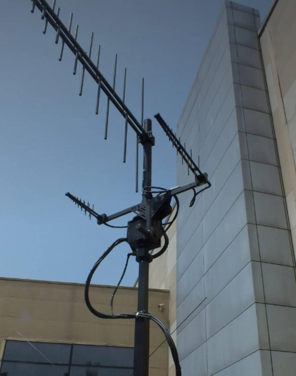 Rotator carrying an antenna array on a building facade