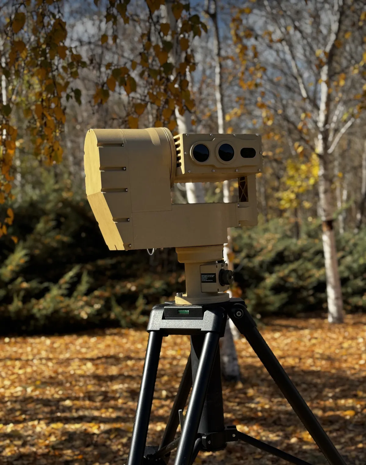 Pan-tilt unit with a multi-channel imaging payload on a tripod in a wood