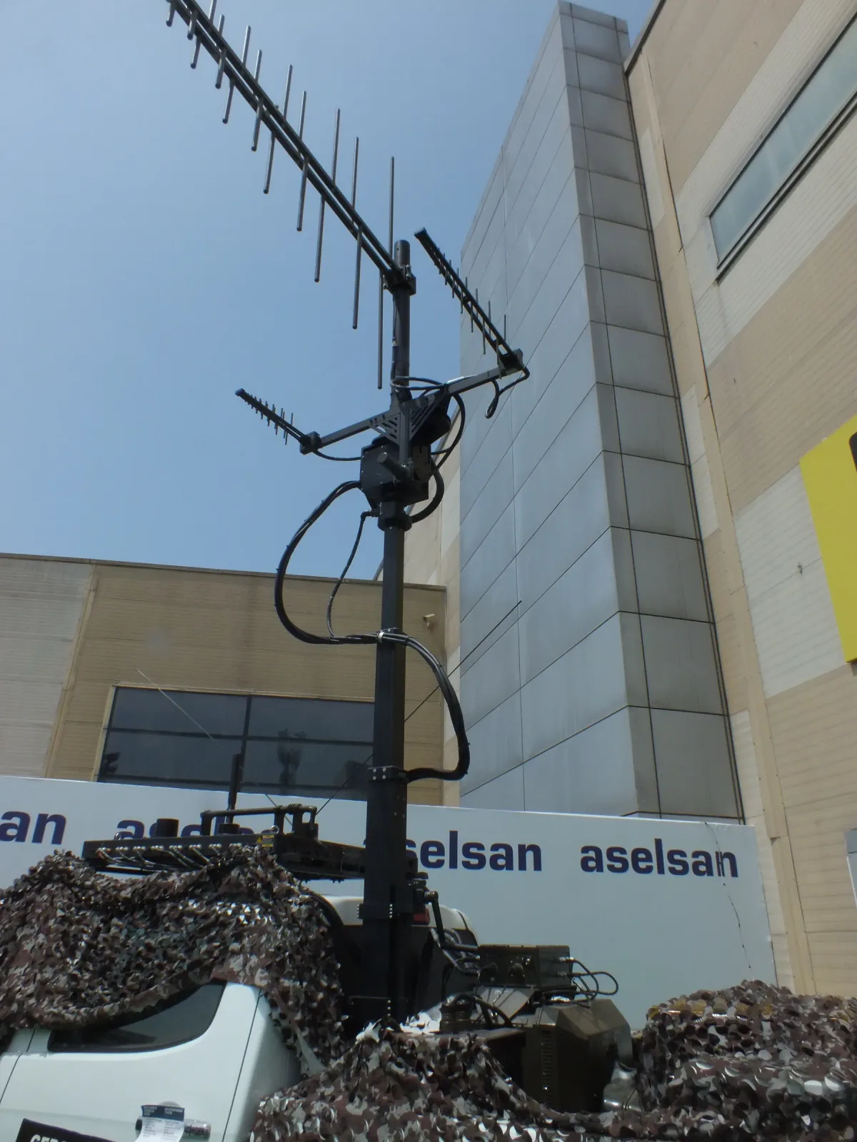 A manual telescopic mast extended on the stand, carrying its payload above the vehicle.