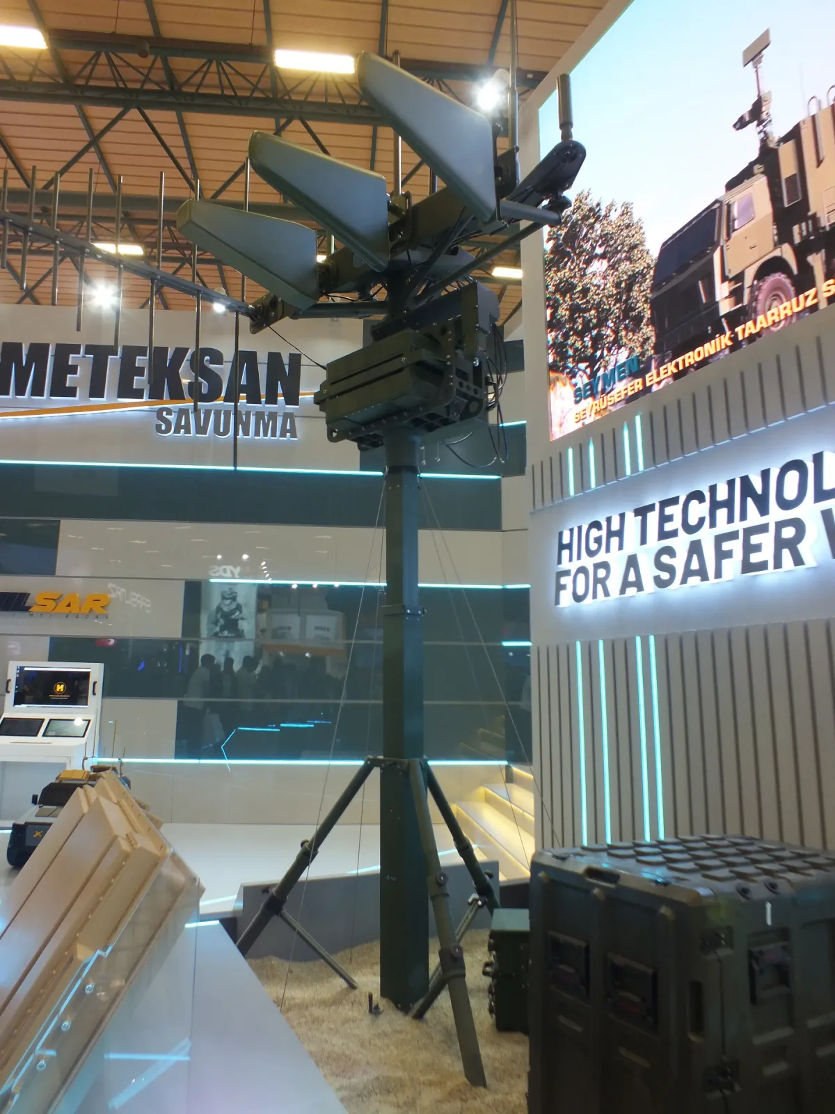 A manual telescopic mast on the stand carrying a directional antenna array at height.