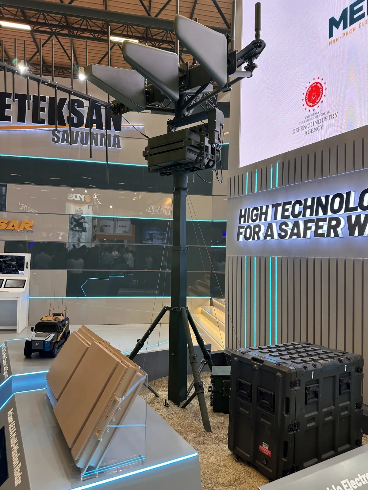 A manual telescopic mast on the stand carrying a directional antenna array at height.