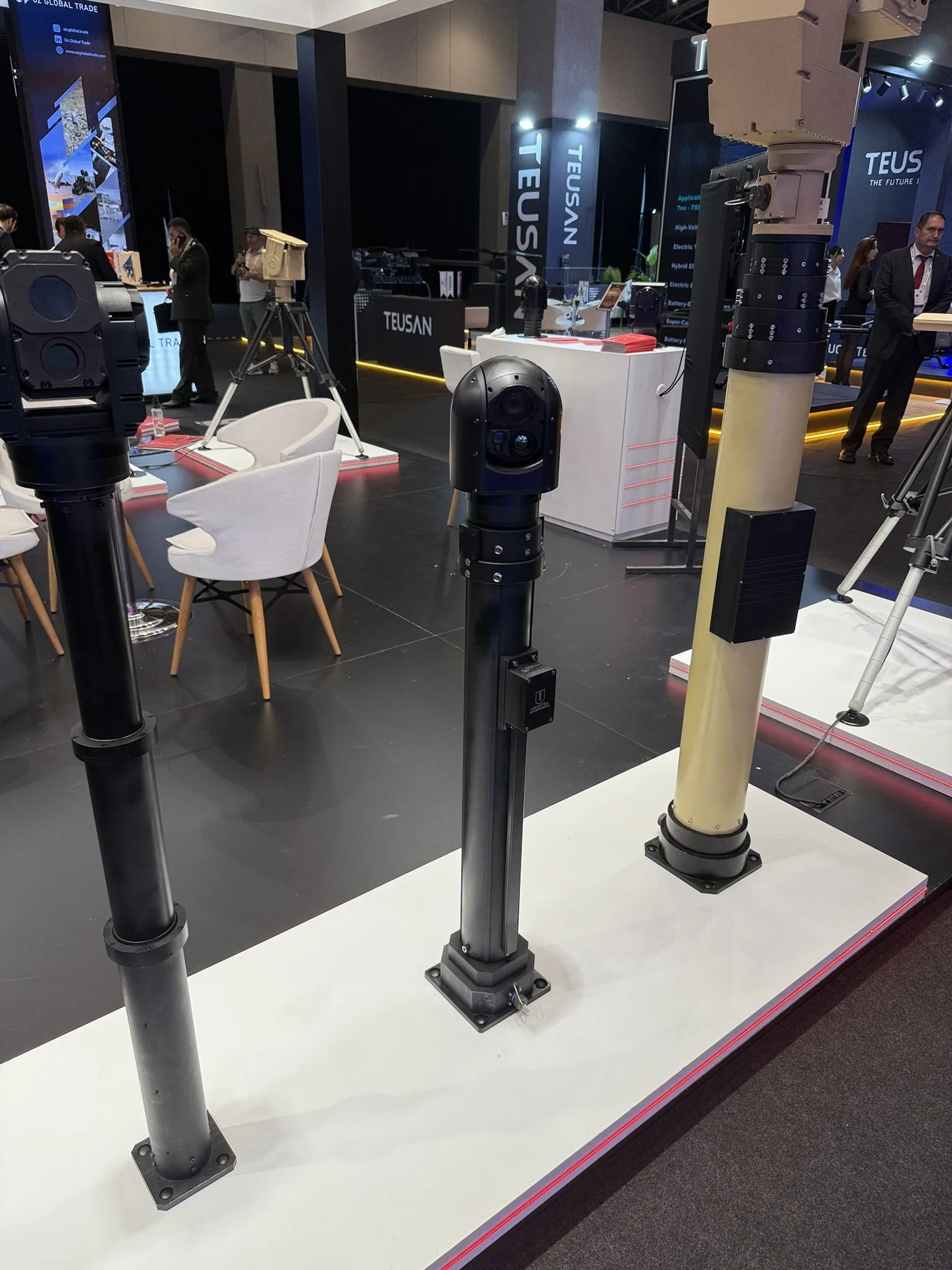 Black masts topped with a box-type and a dome-type gimbal, a sand-coloured mast on the right.