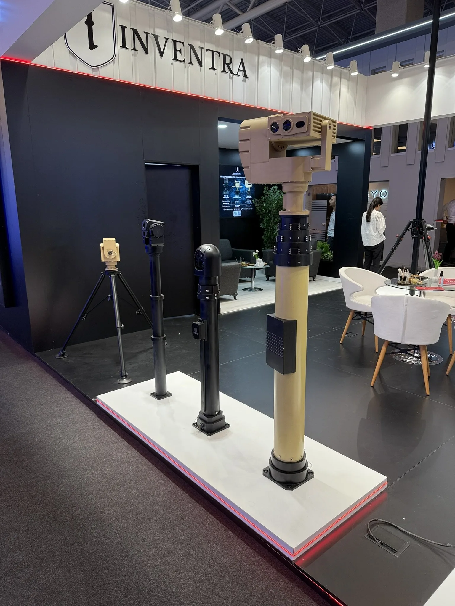 Three masts side by side on the platform, one carrying a sand-coloured twin-aperture payload, with a small tripod behind.