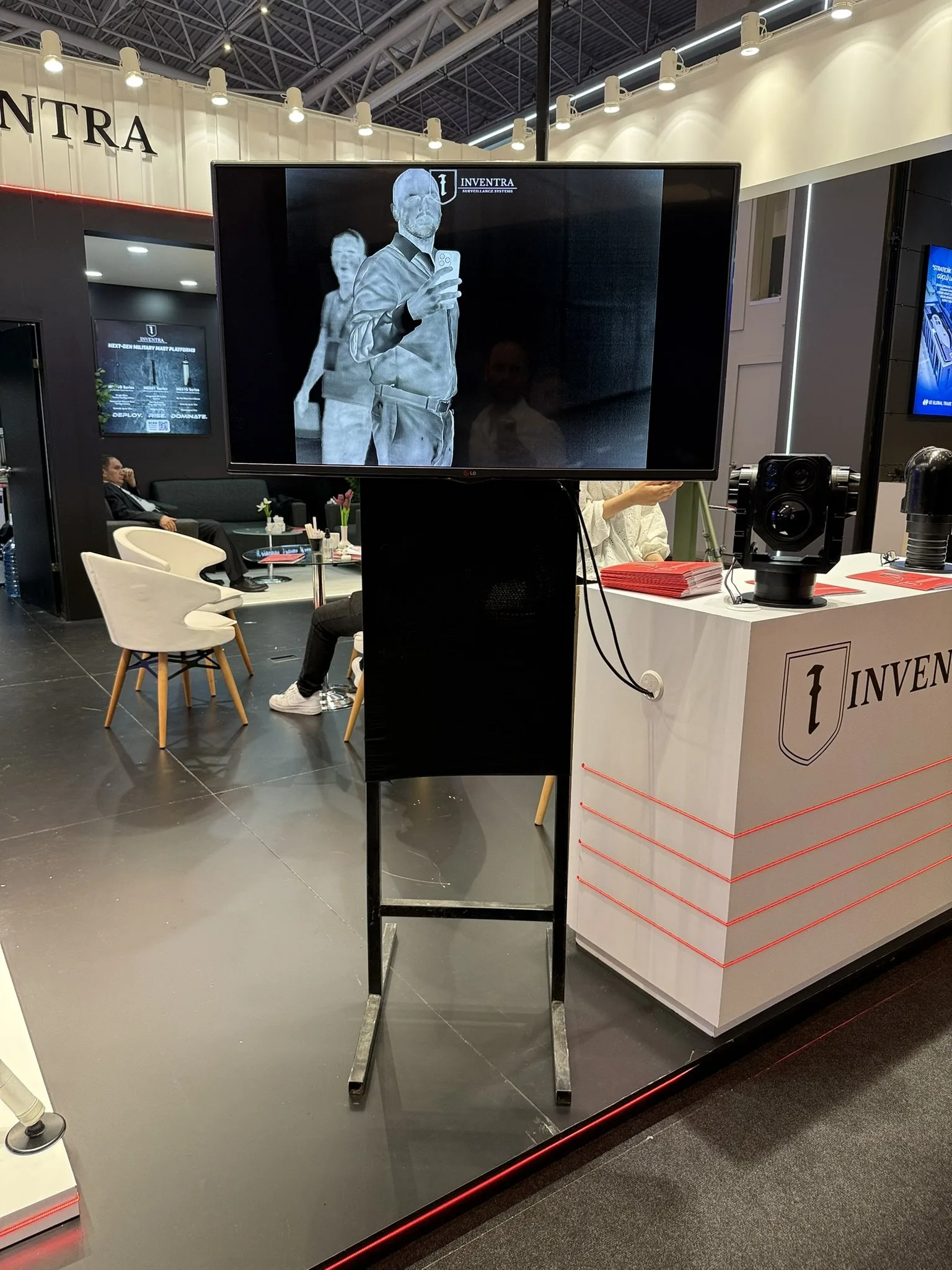 A screen on a floor stand showing a thermal image, beside the counter with two gimbals on it.