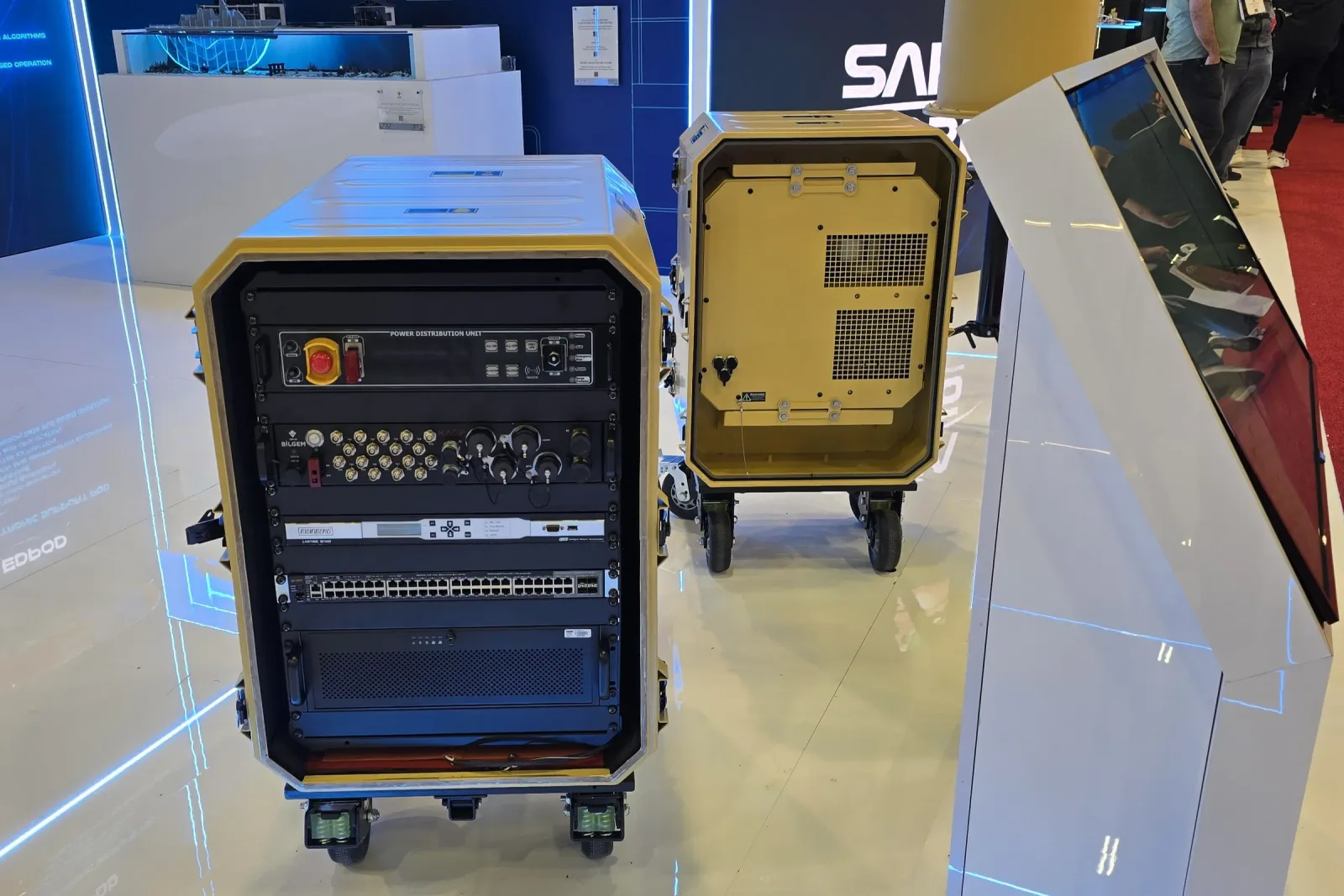 An open rack cabin beside a closed one, the rack equipment and cabling visible through the opening.