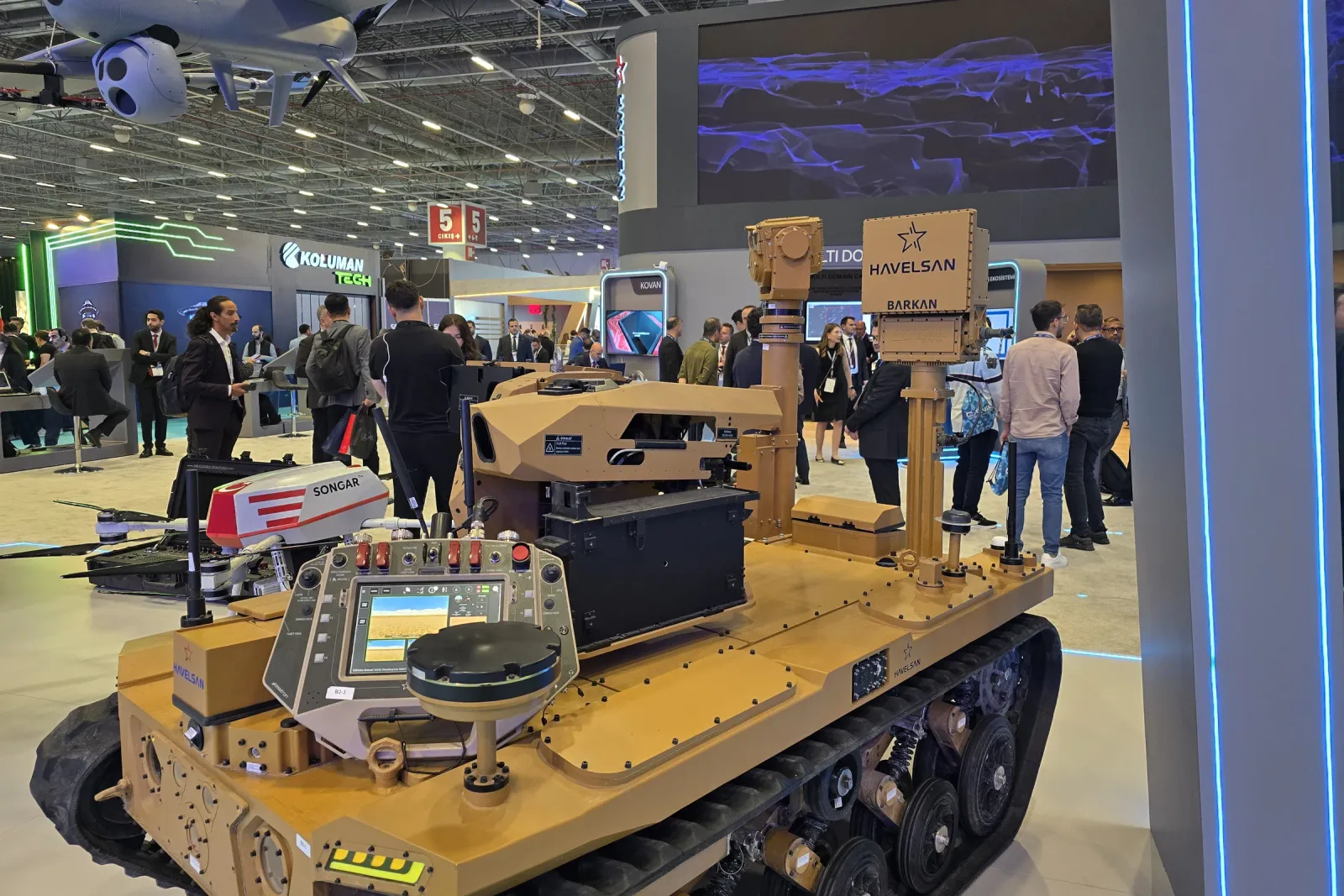 The tracked vehicle photographed along its length, the mast and gimbal rising from the rear deck.