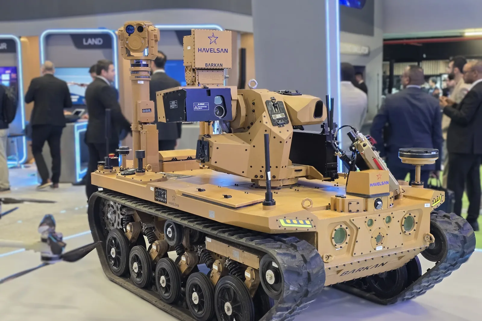 The tracked vehicle seen from the side with the mast fully raised, the gimbal at its head.