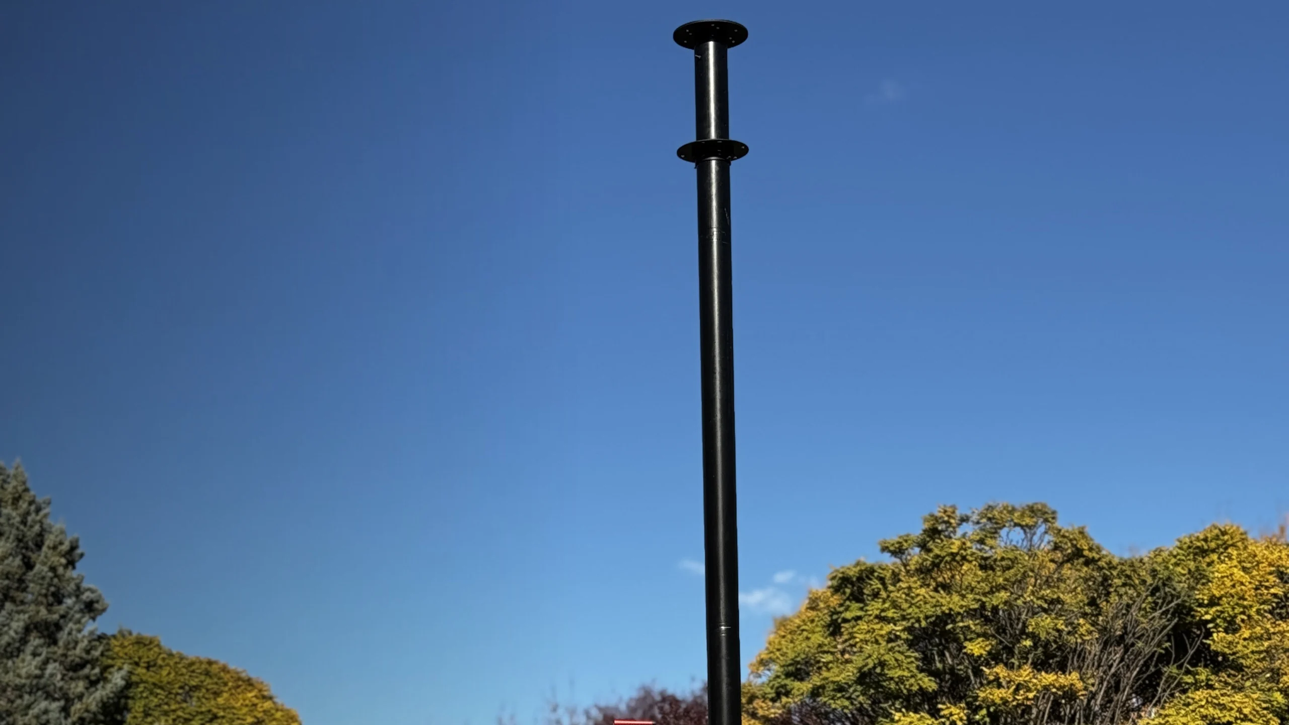Telescopic mast deployed in the field against a blue sky
