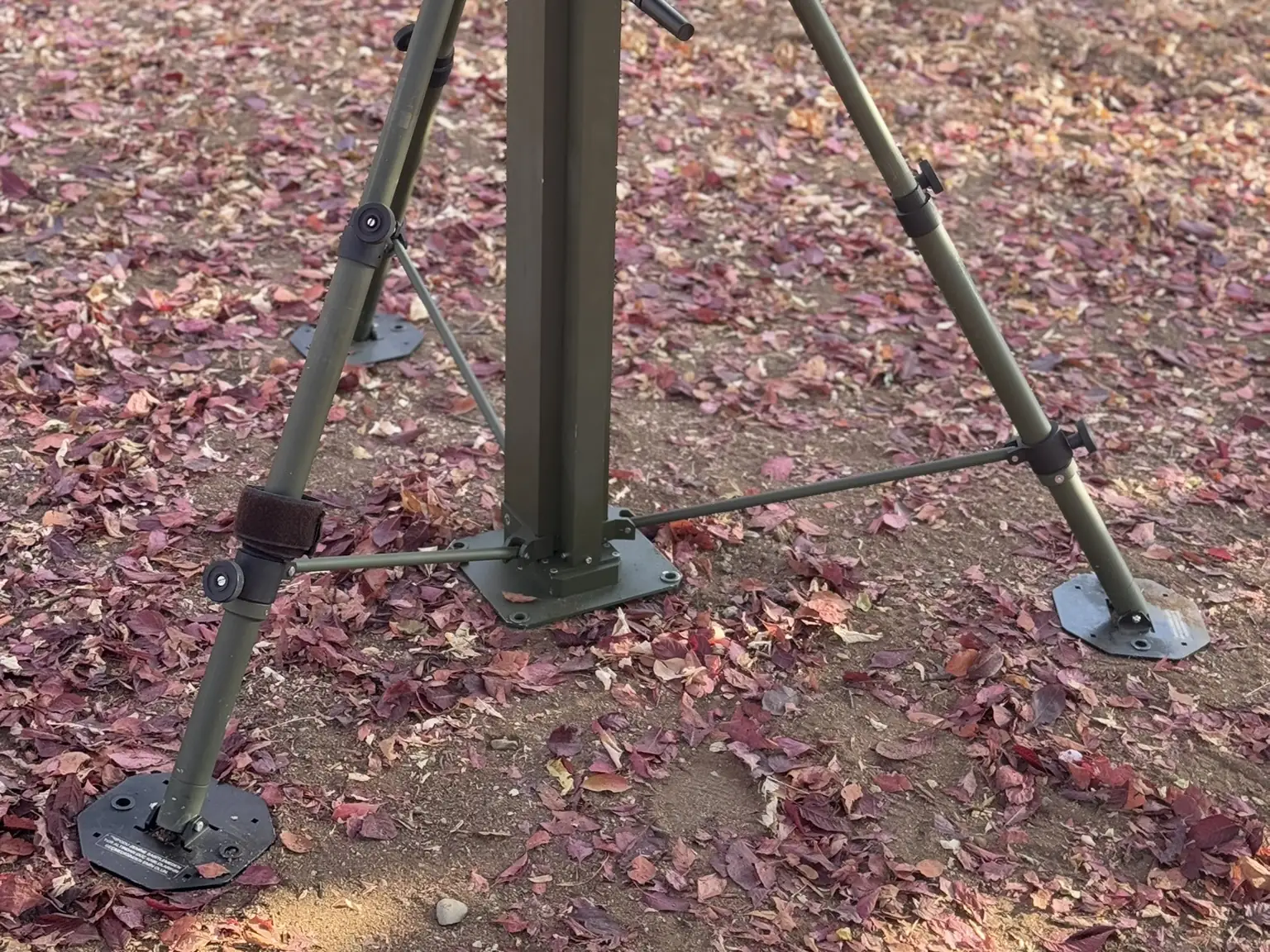Tripod legs fully spread, showing the base pads and the guying mechanism