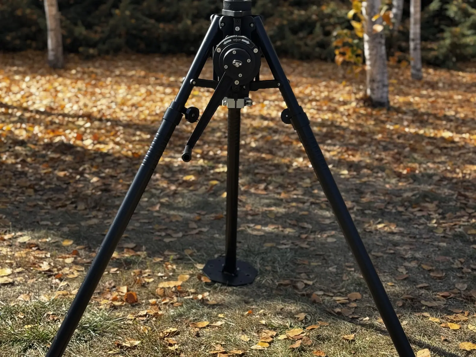 Tripod fully spread with the mast retracted, at three-quarter angle — the transport and setup position