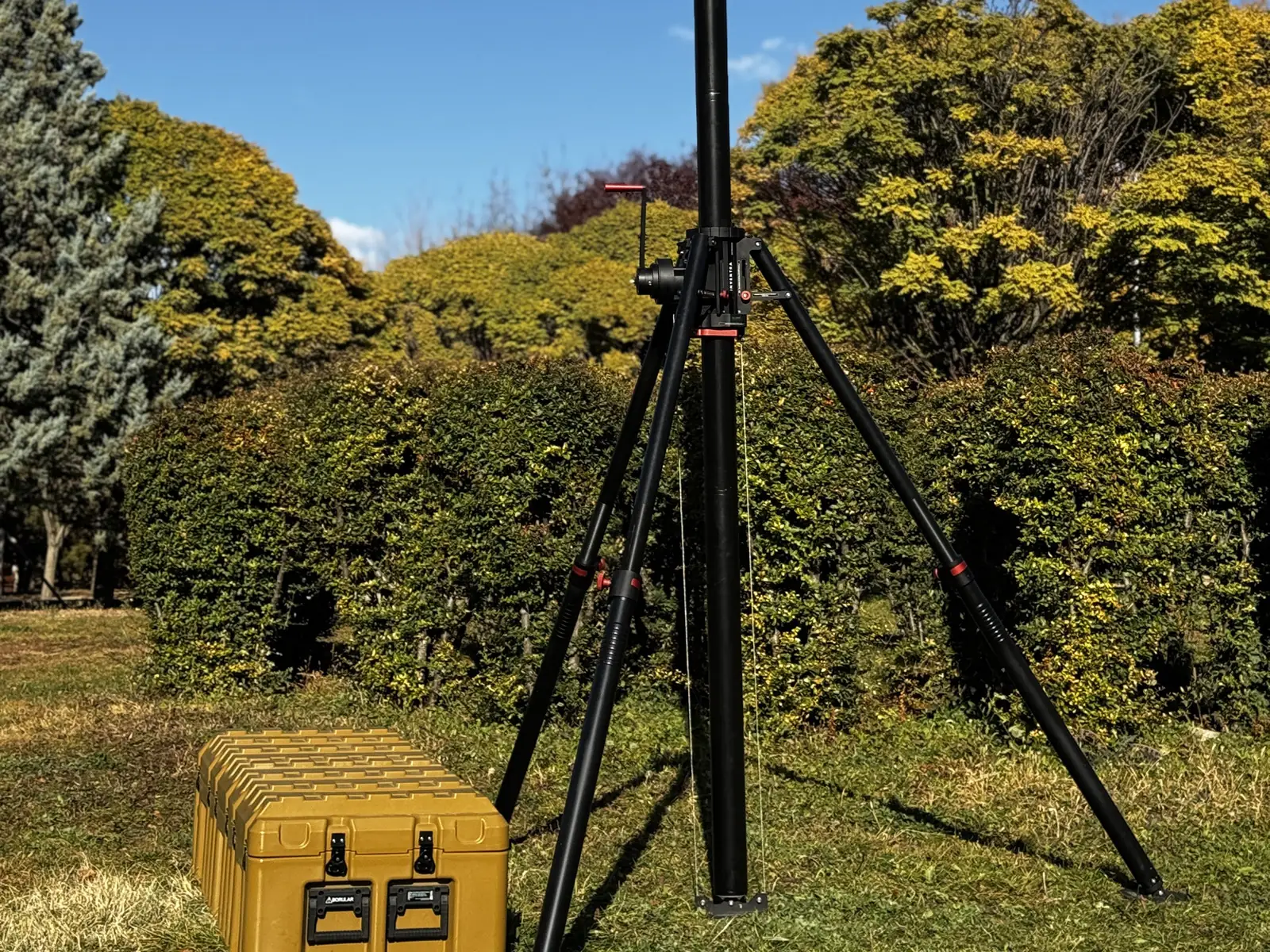 System set up in a garden against a blue sky, with a yellow transport case at left giving scale