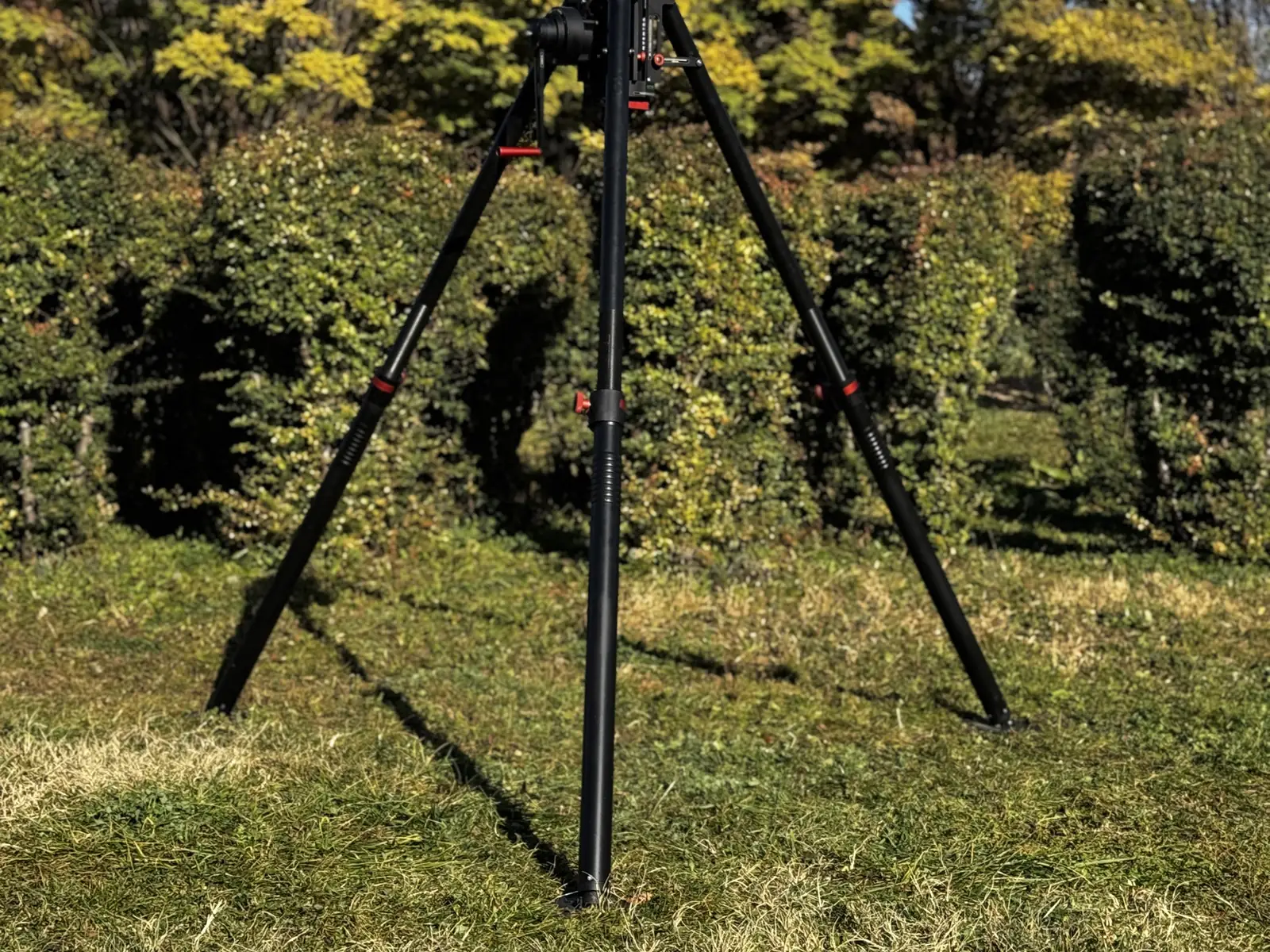 Tripod fully spread with the mast retracted, showing the red leg locks