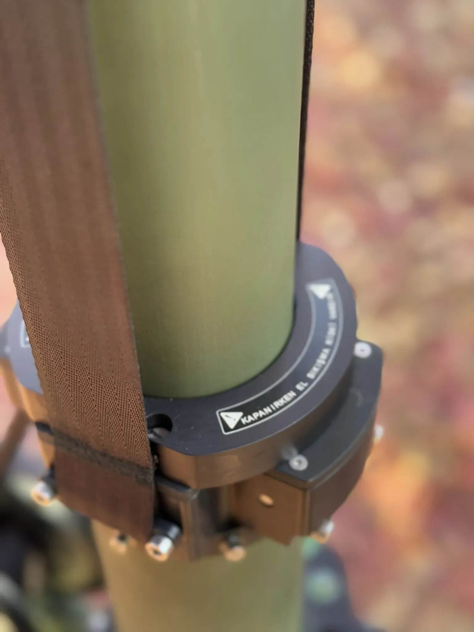 Close-up of the clamping collar and lifting strap wrapped around the olive telescopic tube.