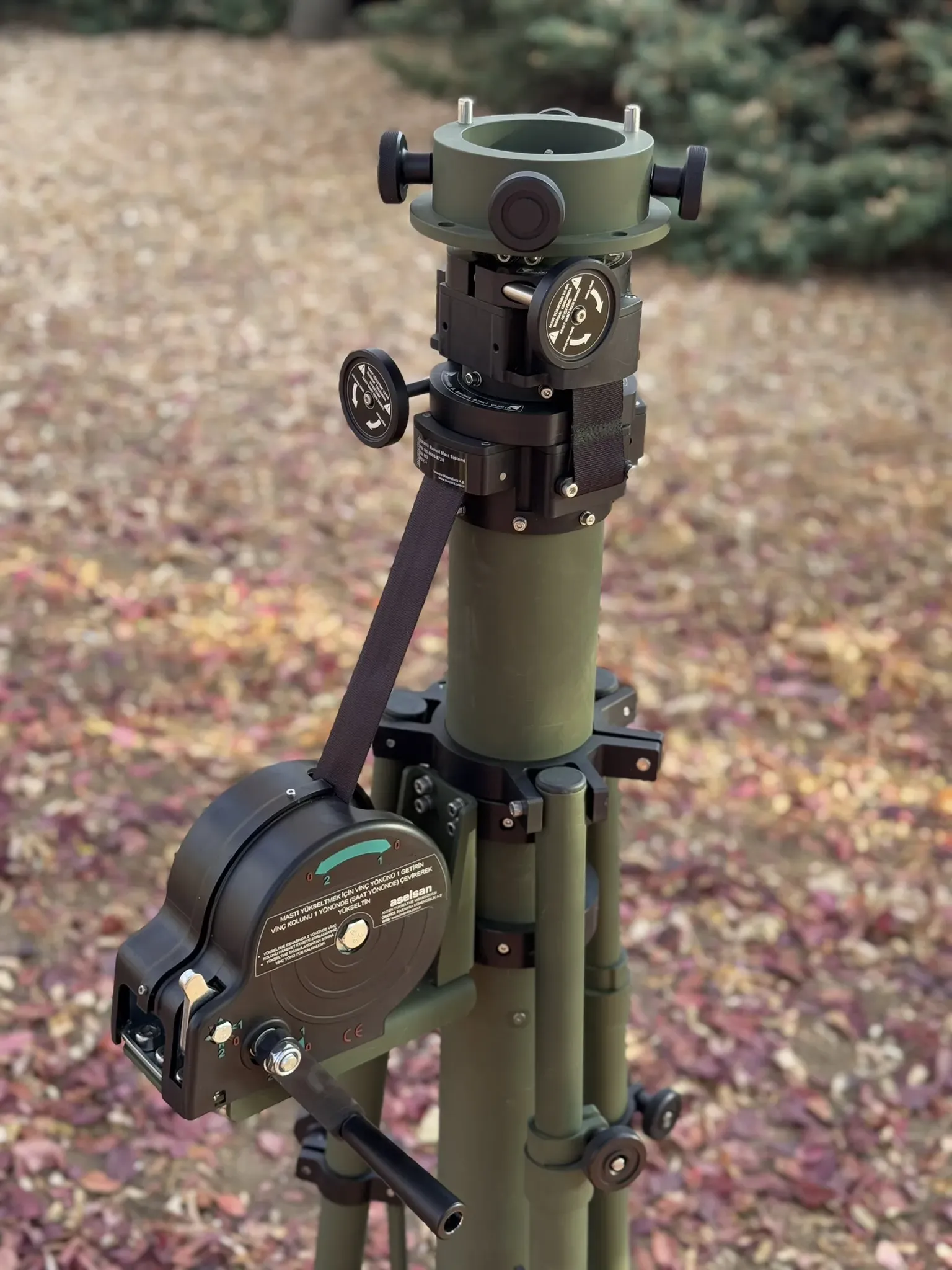 Three-quarter view of the mast head, rotator knobs and side-mounted winch above the tripod.