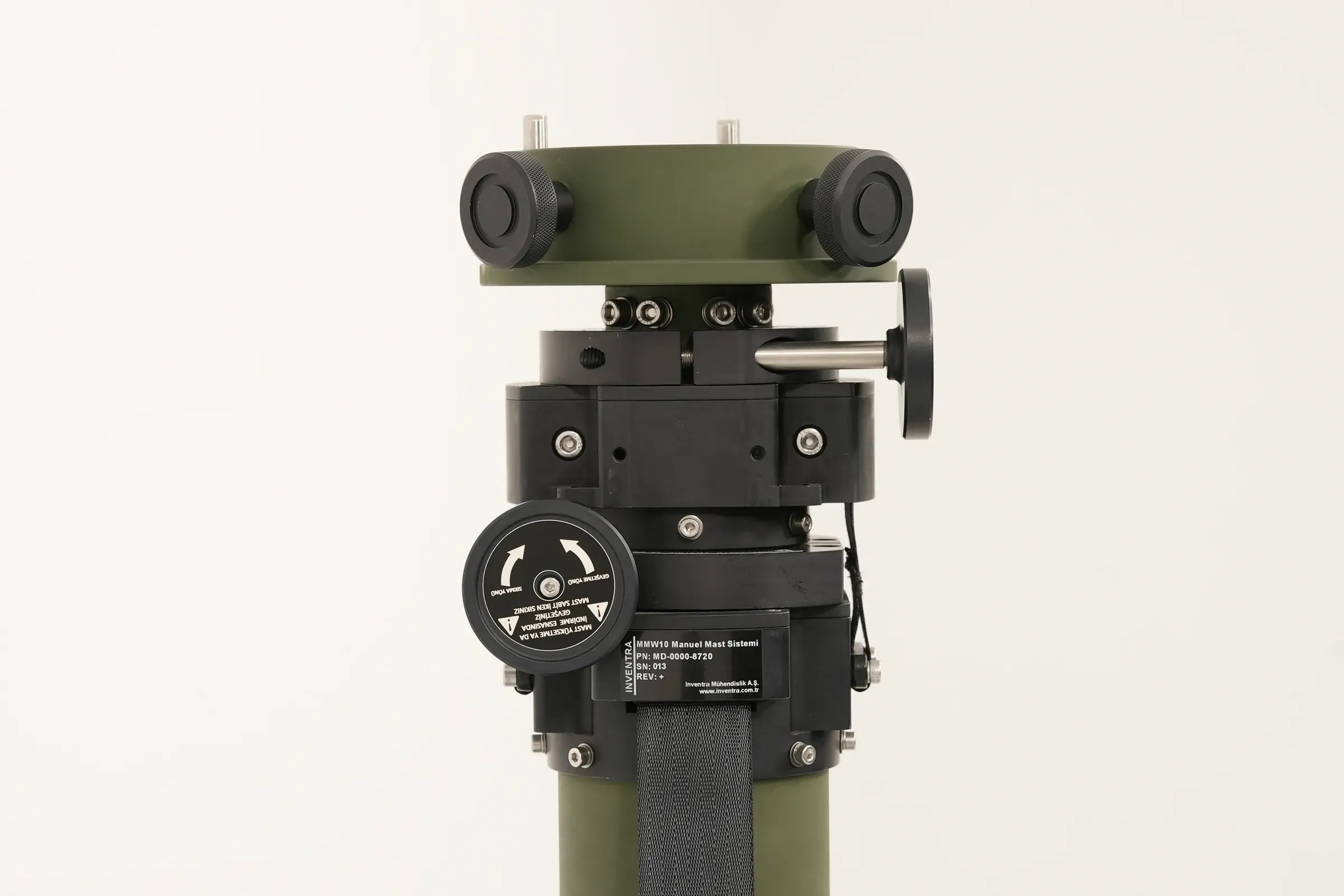 Side view of the black head assembly and clamp mechanism at the top of the olive green mast tube.