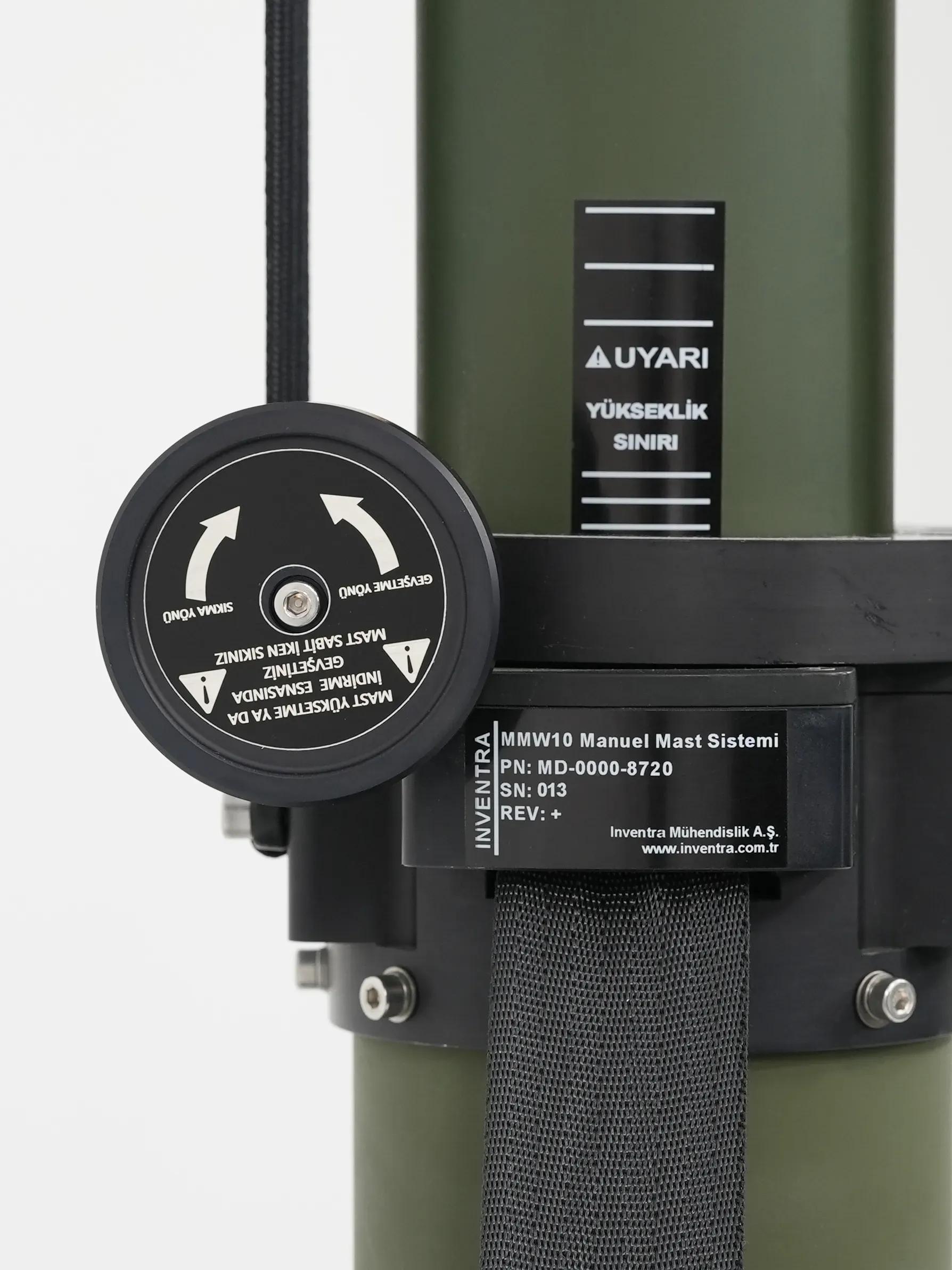 Mid-mast detail of the black cable guide, warning plate and product data label on the green tube.