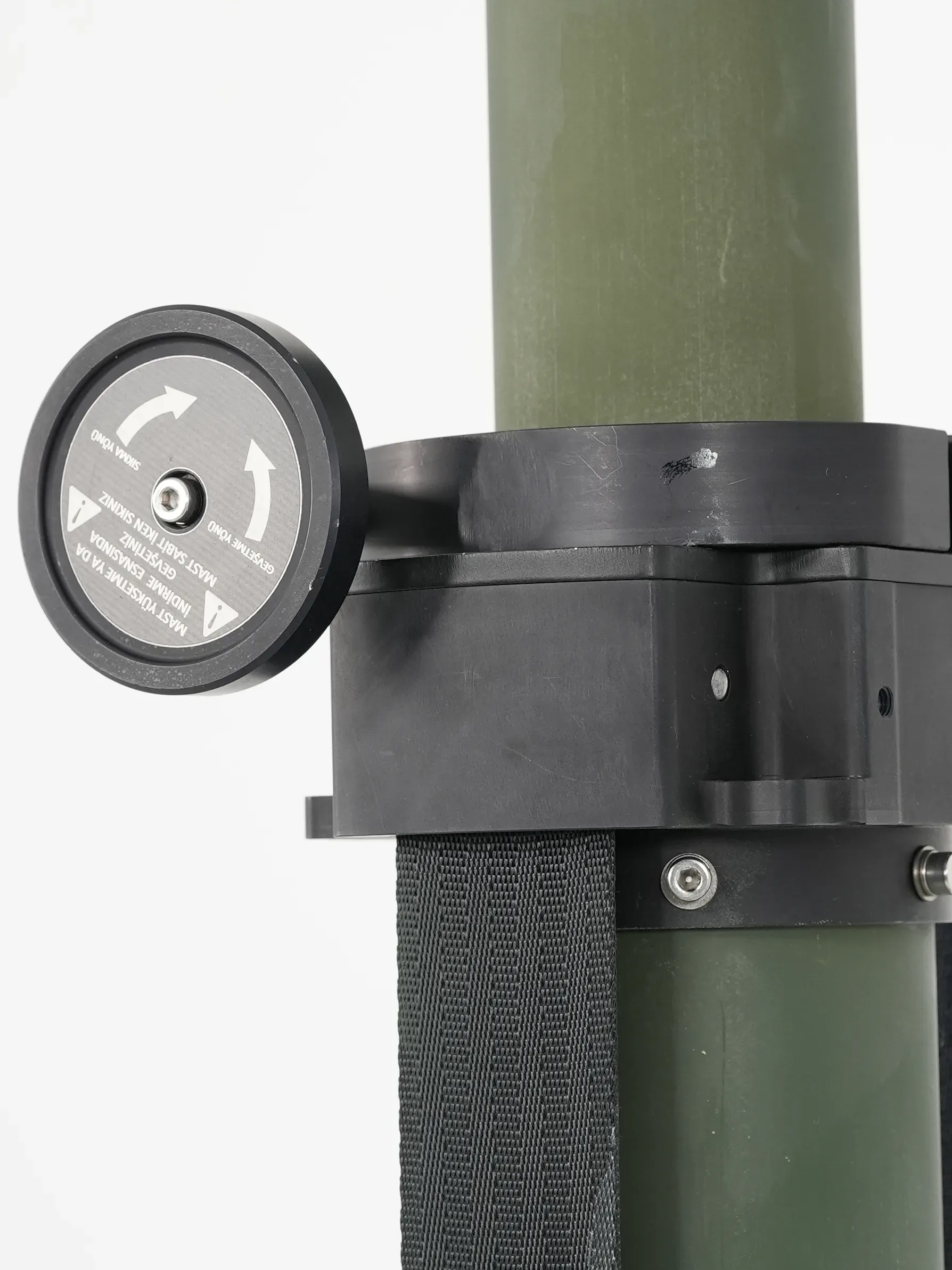 Side detail of the black rotating collar with dial marking and webbing strap on the green mast tube.