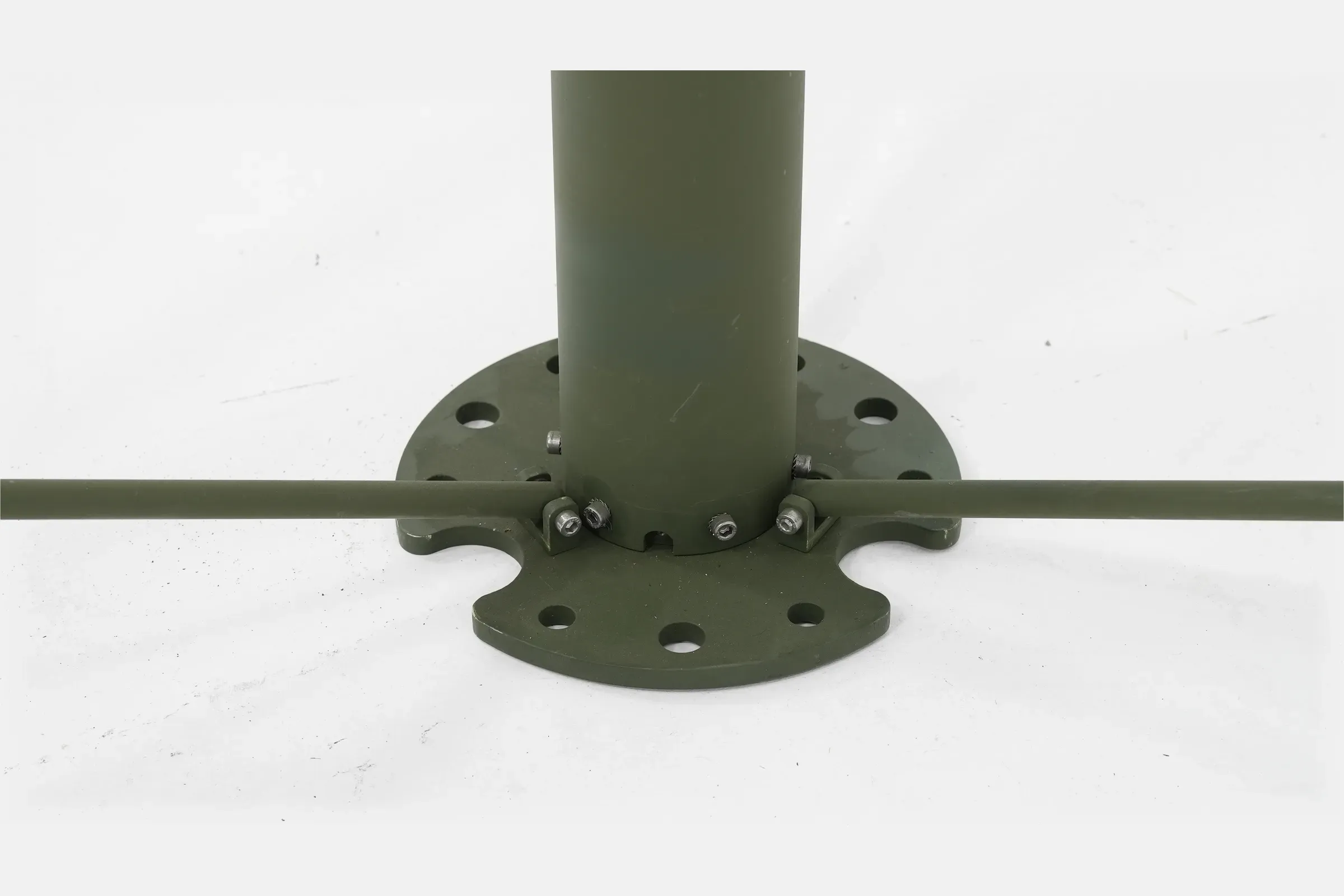 Base flange detail where the olive green mast tube bolts onto a circular ground plate with leg strut.