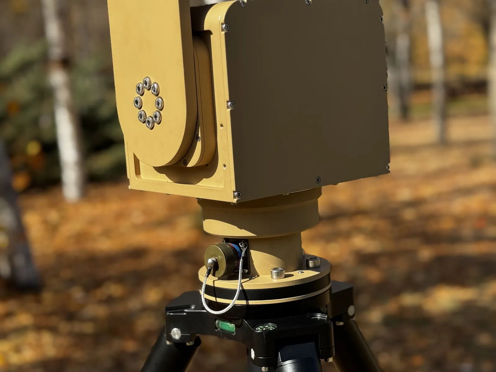 In the field on a tripod, from a left-rear three-quarter angle showing the tilt bearing and the inner face of the U-arm