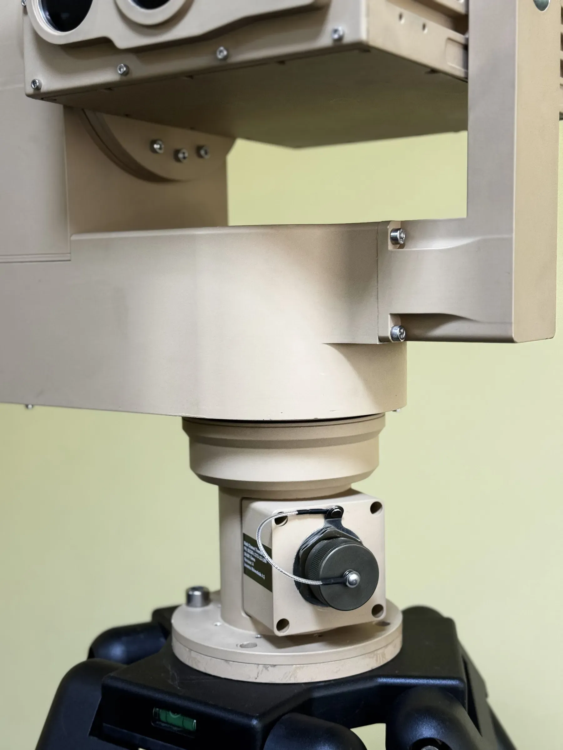 Indoor close-up of the PED12 azimuth column and drive motor beneath the tilted SEB20 payload, tripod head below.