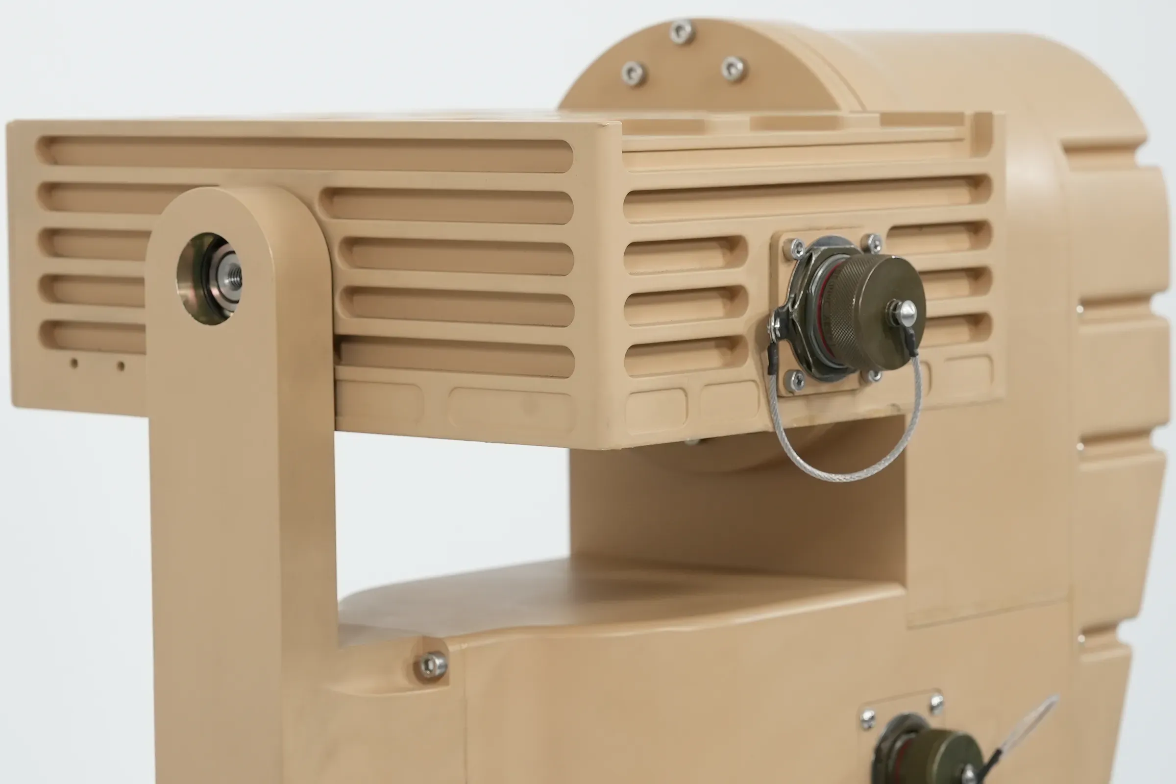 Close-up of the tan PED12 finned payload housing and pivot arm with tethered connector cap.