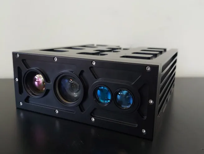 Black SEB20 thermal imager module resting on a dark desk, showing four front lenses including two blue-coated apertures.