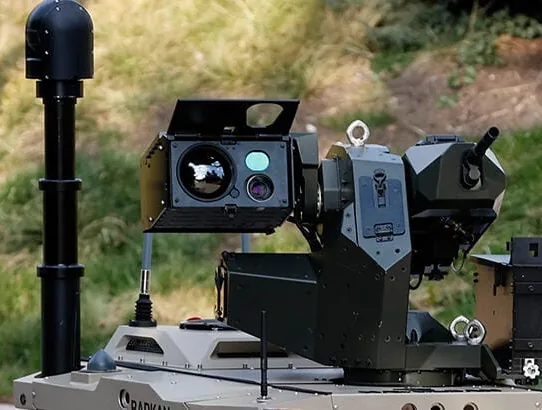 SEG10 gimbal and mast fitted to a tracked unmanned ground vehicle with weapon station, parked on grass.