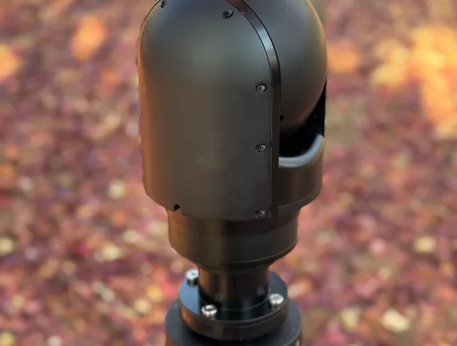 Rear three-quarter view of the SEG10 gimbal head on its mast collar, sensor window facing away.