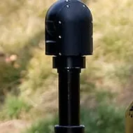 Close crop of the head on the mast above the vehicle deck, hillside blurred behind.