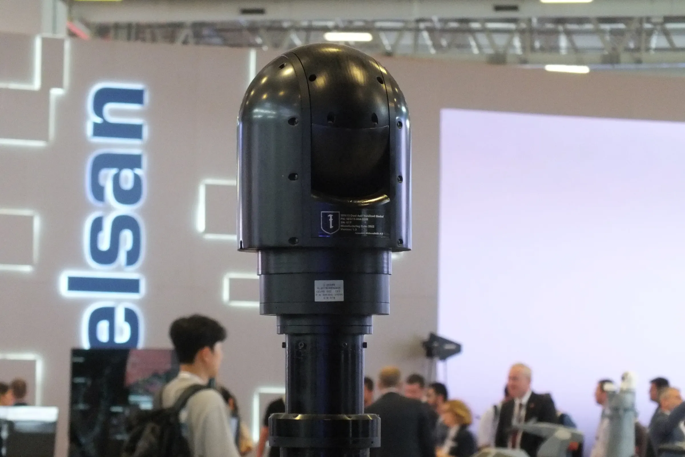 Close view of the black SEG10 gimbal head on the extended MES01 mast in front of the ASELSAN stand lettering.
