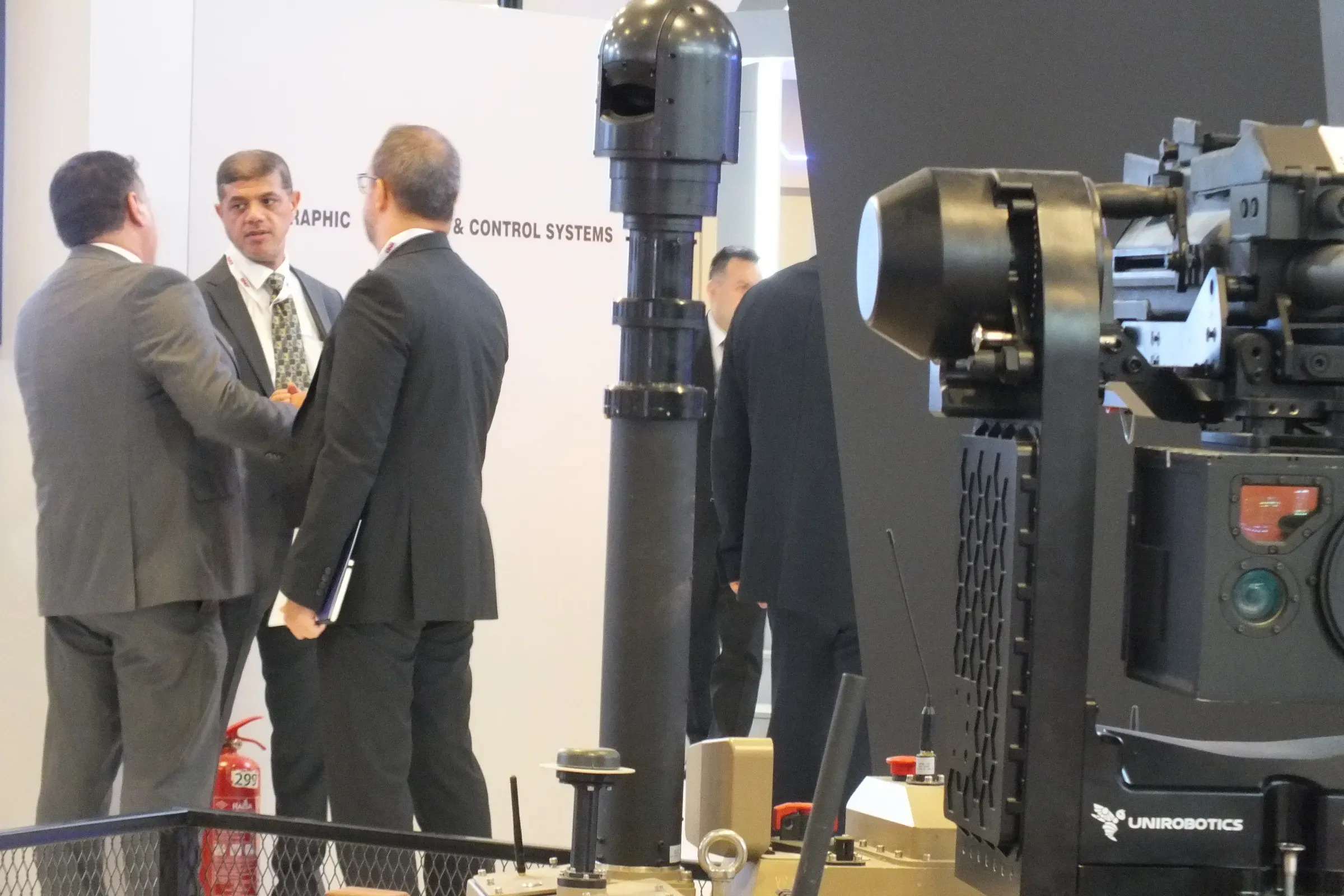 MES01 mast raised with SEG10 sensor head next to a remote weapon station, suits conversing at the stand.