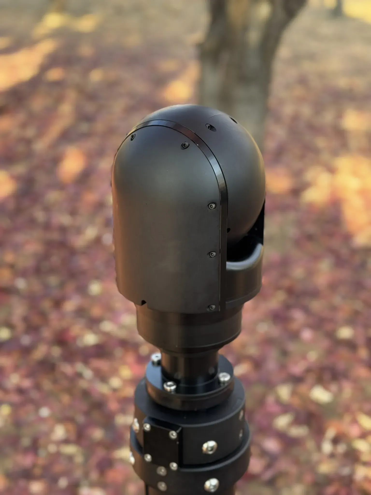 Rear three-quarter view of the SEG10 gimbal head on its mast collar, sensor window facing away.