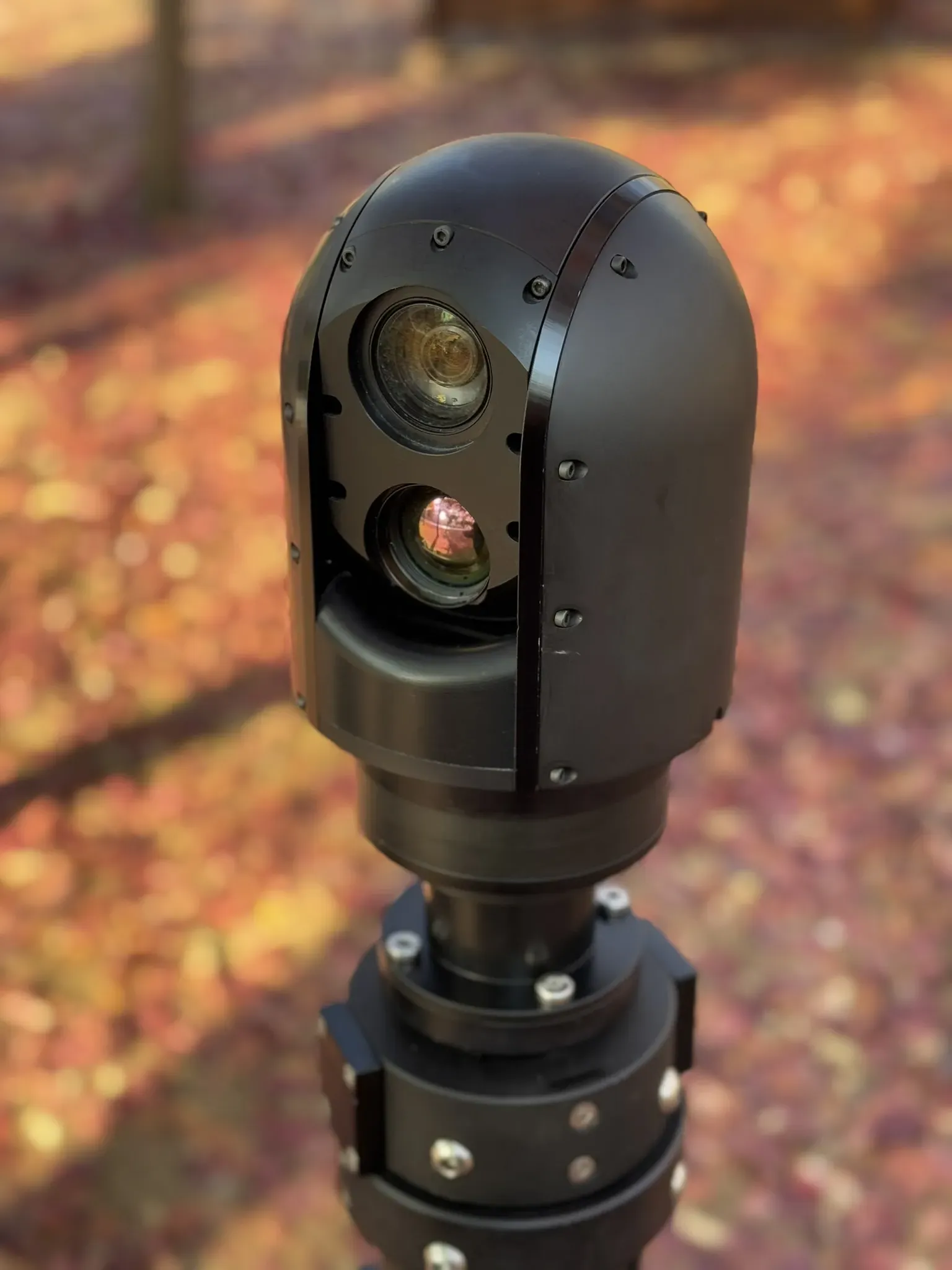 Close front view of the SEG10 gimbal head, day and thermal lenses catching low sun.