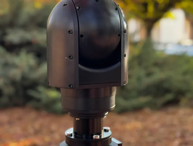 Rear three-quarter view of the SEG12 gimbal turned away, mounted on a positioner outdoors.