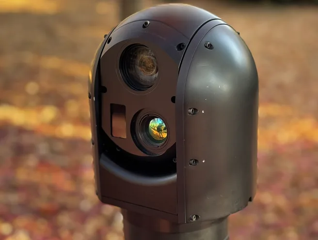 Angled outdoor close-up of the SEG12 gimbal head on the mast, thermal and day windows visible.