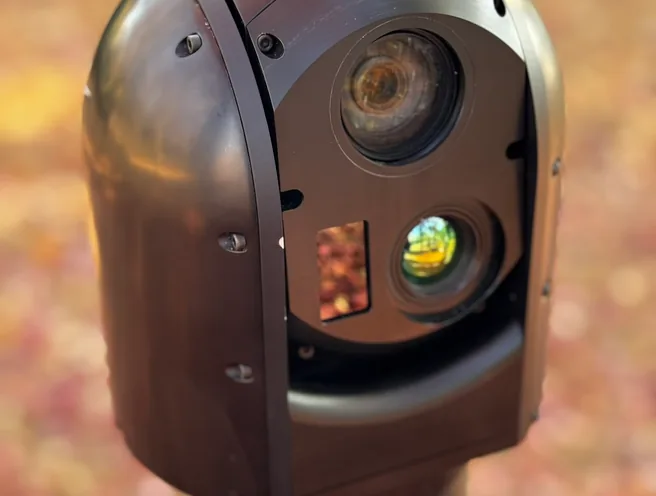 Tight outdoor close-up of the SEG12 gimbal head filling the frame with lenses catching sunlight.