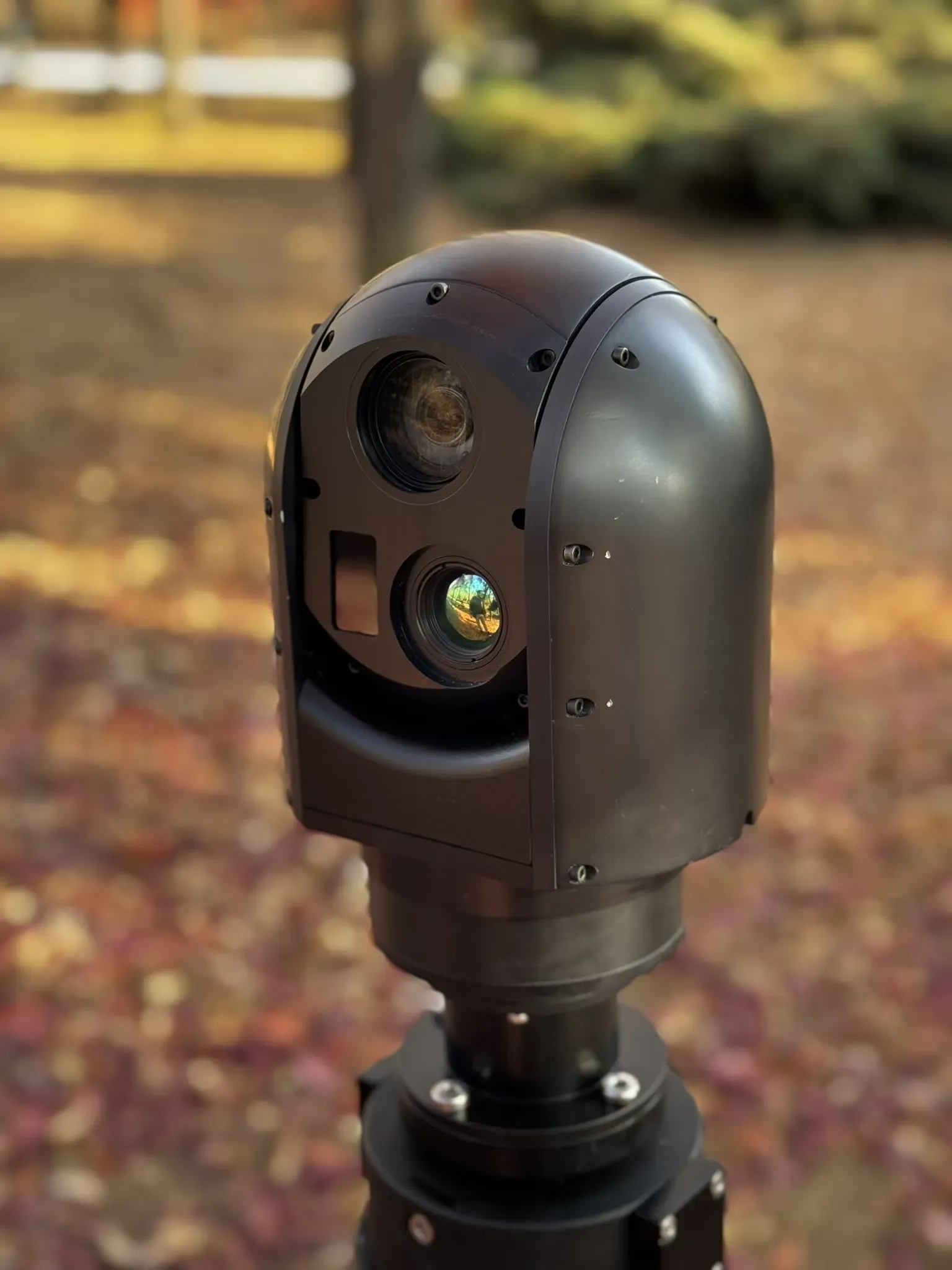 Angled outdoor close-up of the SEG12 gimbal head on the mast, thermal and day windows visible.