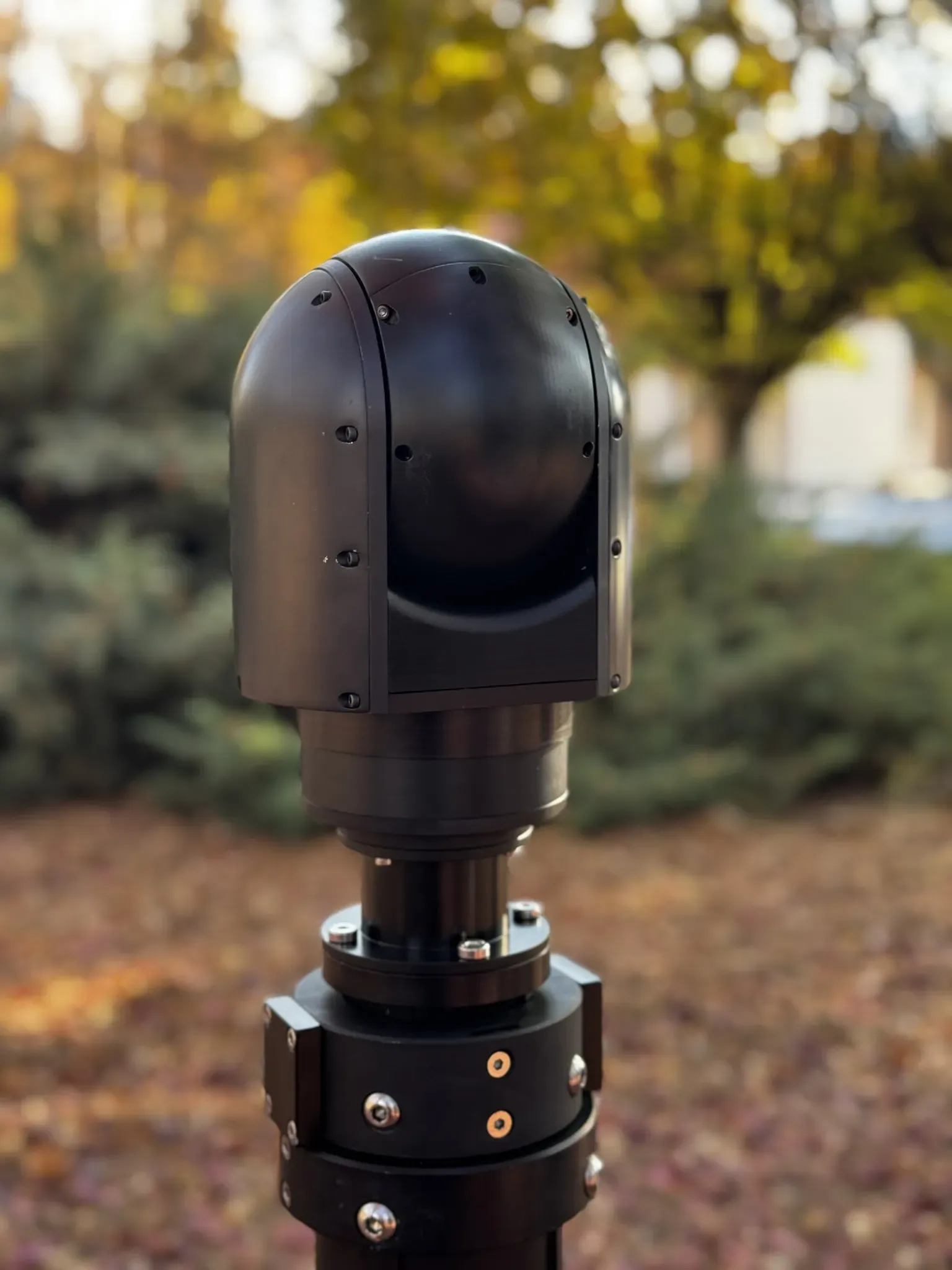 Rear three-quarter view of the SEG12 gimbal turned away, mounted on a positioner outdoors.