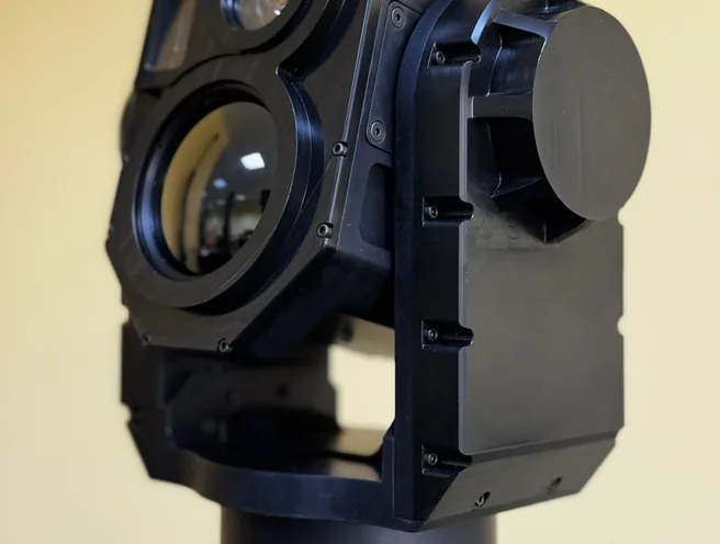 Three-quarter close-up of the open-frame SEG14 gimbal with lens caps fitted on the mast top.