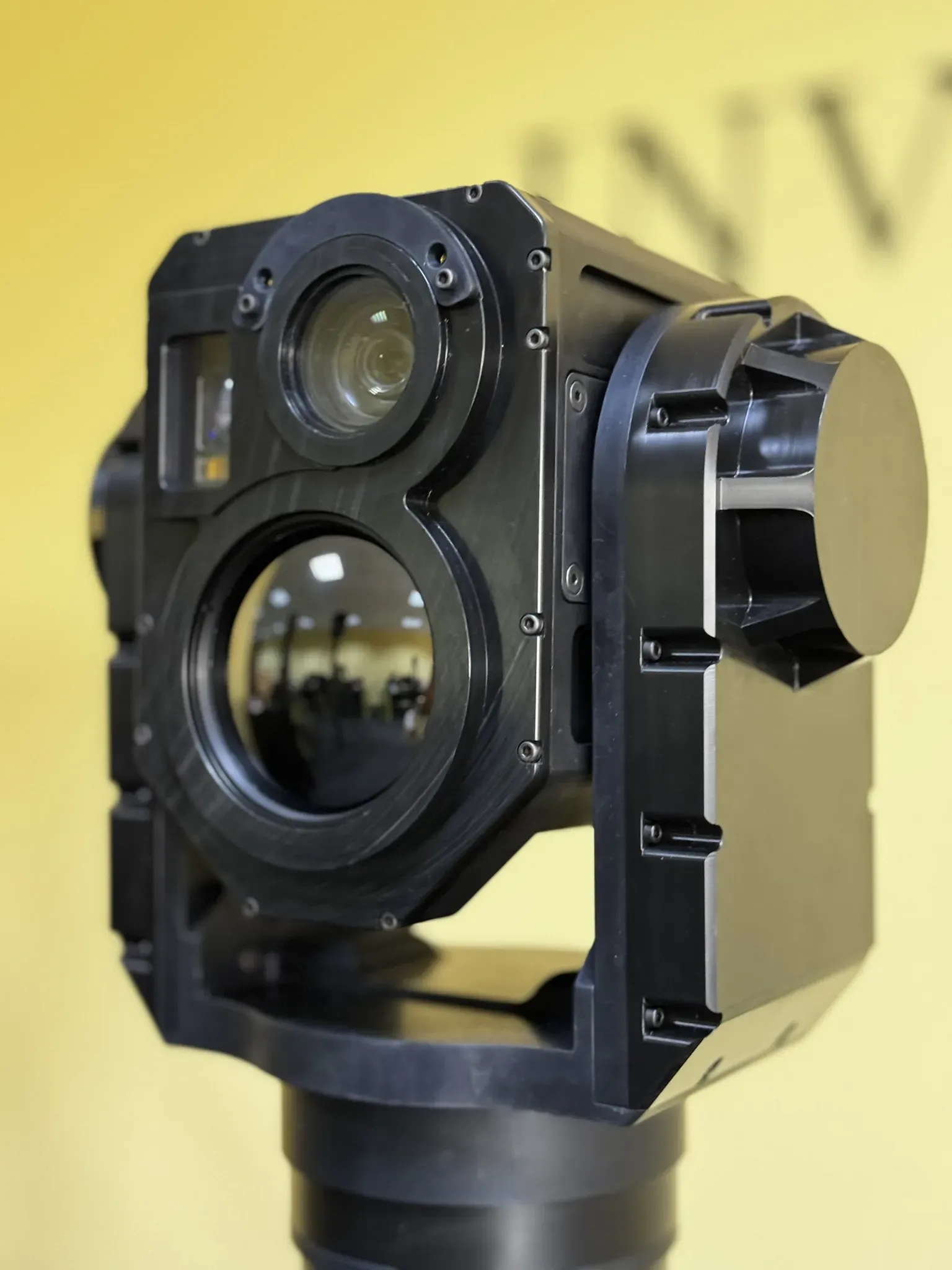 SEG14 gimbal photographed from slightly below in its yoke, main optics facing the camera.