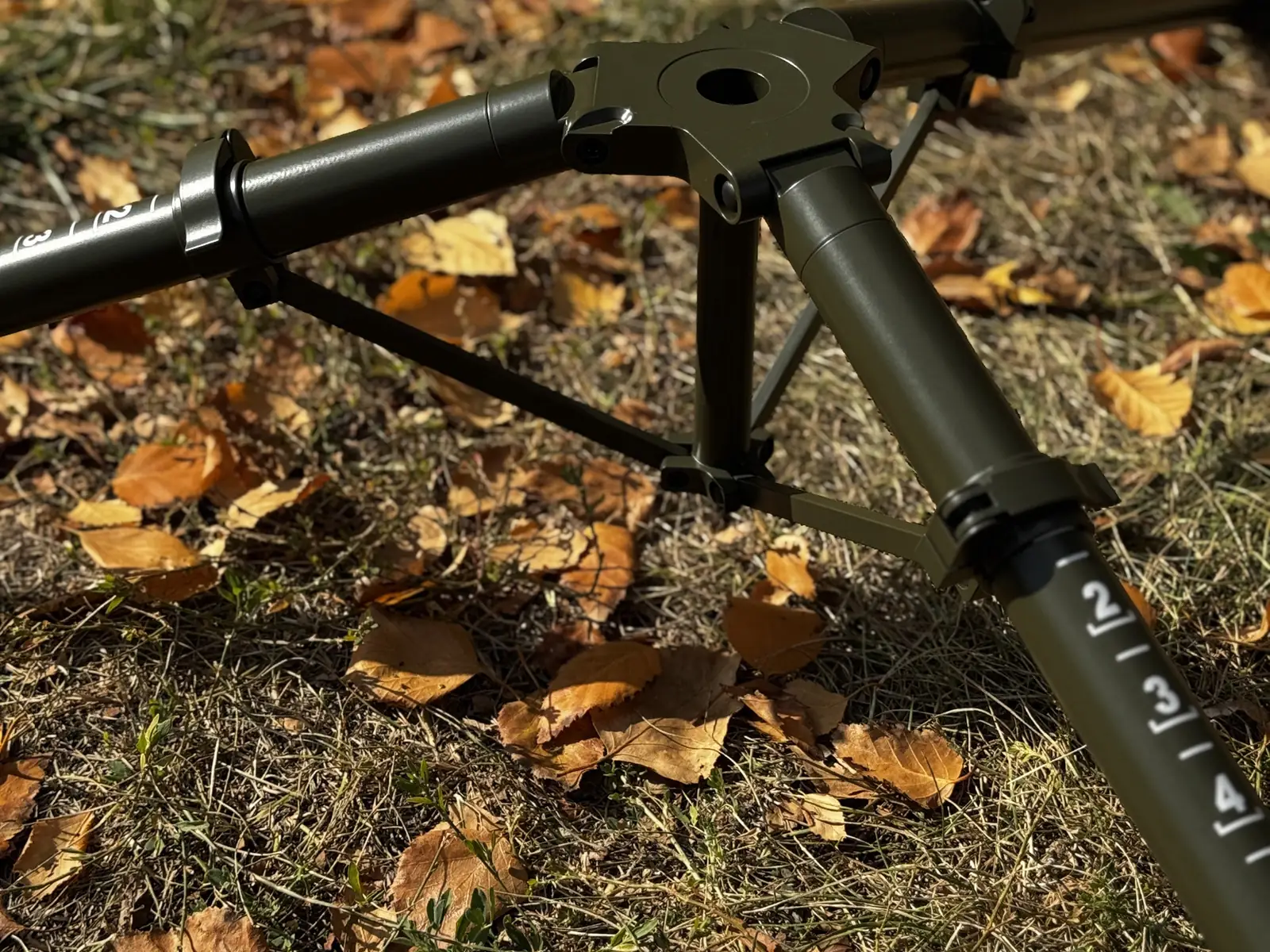 Close view of the mounting interface with the tripod lying down: top hub plate, centre hole and the three leg joints