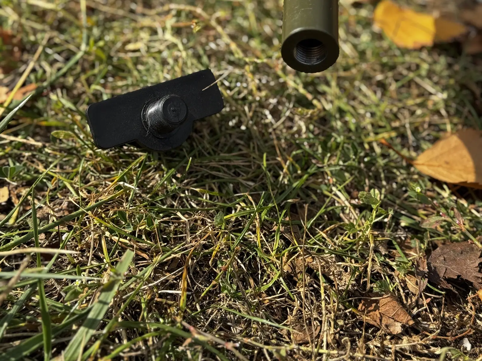 Threaded end of a leg tube next to the removable spike foot — the interchangeable foot accessory